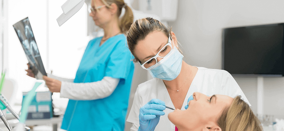 dentiste contrôlant les dents d'un patient